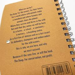 The Deep's mantra is printed on the back of the spiral bound notebook.