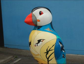 The Deep's puffin sculpture outside the building, against a blue wall.