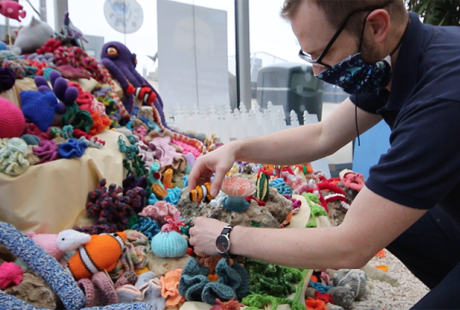 Aquarist arranging sea themed crocheted items